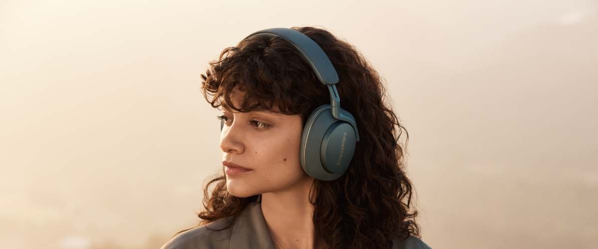 Naine vaatamas kaugusesse Bowers & Wilkins rohelised kõrvaklapid peas